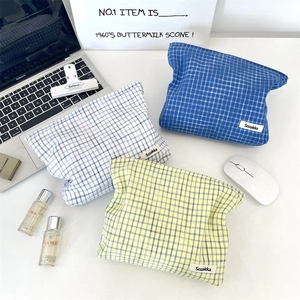 Flat lay of stylish checkered cotton cosmetic bags in blue, green, and white patterns