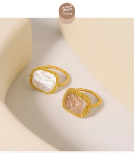 Detailed shot of baroque square pearl rings with gold spiral bands in luxury setting