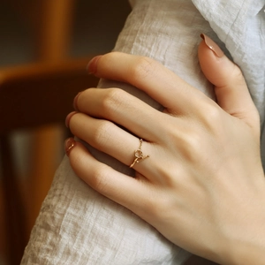 Elegant gold minimalist ring with toggle clasp design on female model's hand