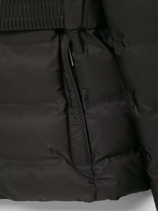 Close-up of black windproof jacket featuring a hidden zipper pocket and elastic waist texture