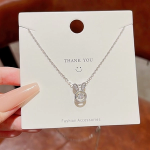Macro detail of silver bunny pendant necklace with a sparkling round central diamond