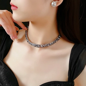 Close-up of model wearing silver diamond square necklace and stud earrings set