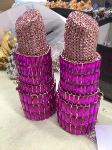 Macro view showing pink rhinestone lipstick clutch evening bag with metal frame detail