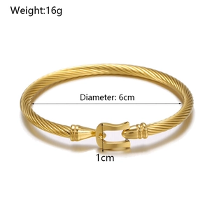 Detailed view of golden twisted steel cuff with 16g weight and 6cm diameter specifications
