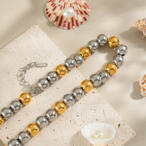 Detail of mixed gold and silver bead necklace on stone with sea shells and pearls