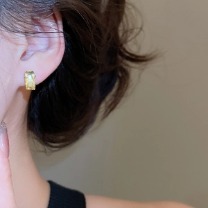 Close-up of model wearing emerald cut yellow zircon earrings with silver claw setting