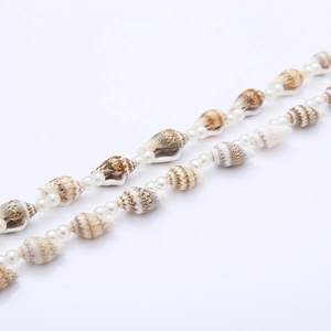 Macro shot of natural brown seashells and glossy white beads on a bohemian necklace