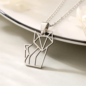 Close-up of silver stainless steel fox pendant necklace with geometric lines on white petals