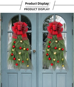 Detail of teardrop Christmas swags with red plaid bows and ornaments on blue doors
