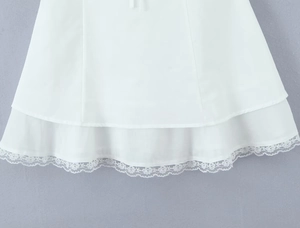 Close-up of white double-layered skirt hem with delicate lace trim and chiffon texture