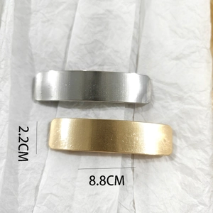Detailed view of 8.8cm gold and silver rectangular metal hair clips with brushed texture