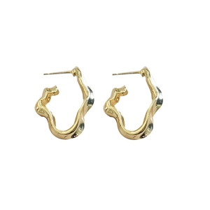 Boucles d'oreilles vagues dorées irrégulières avec aiguille en argent S925 sur fond blanc