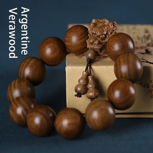 Gros plan de perles en bois de santal vert avec charmes Pixiu et gourde sculptés à la main