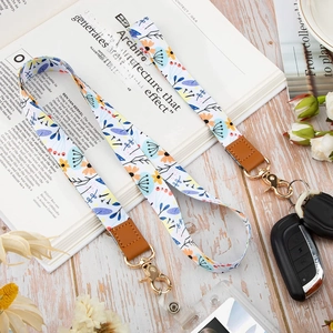 Floral fabric wristlet keychain with brown leather trim and golden metal clasp for car keys