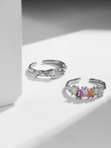 Close-up of adjustable silver rings with rainbow square-cut cubic zirconia gemstones