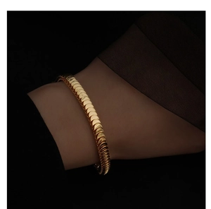 Close-up of golden scale chain bracelet showing a shiny snake bone mesh texture