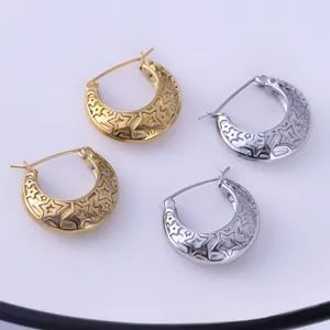 Detailed view of hollow star crescent earrings in polished gold and silver finishes