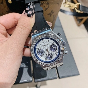 Detail of silver rhinestone bezel quartz watch with black rubber strap on hand