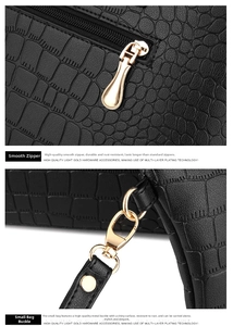 Close-up of golden metal zipper and swivel clasp on black crocodile pattern leather bag