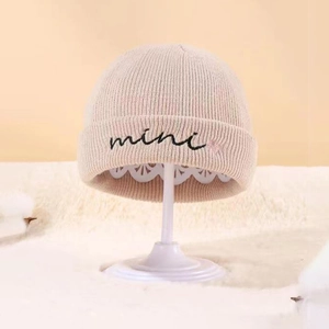 Close-up of ribbed knit beanie with mini embroidery on a white decorative display