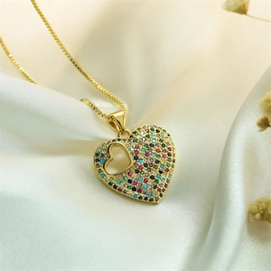 Macro shot of a heart pendant necklace with micro-set zircon on white silk background