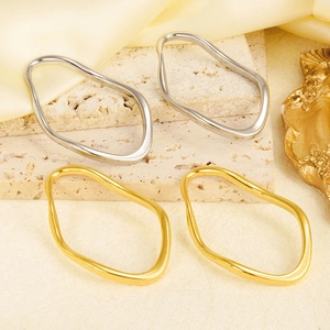 Detail of irregular wave-shaped oval jewelry pendants in gold and silver finish