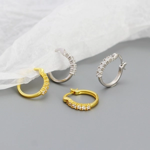 Chic gold and silver hoop earrings with shimmering cubic zirconia on grey background