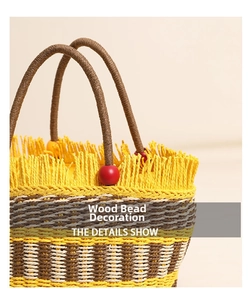 Detail of handwoven bucket bag with fringe trim and decorative red wooden beads on handle