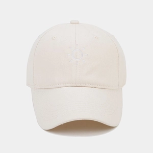 Close-up of cream cotton baseball cap featuring minimalist white sun embroidery detail