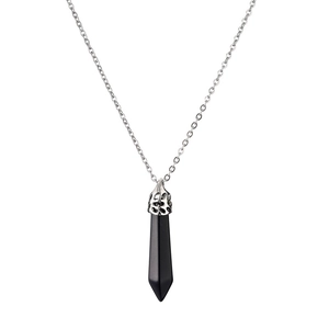 Macro detail of hexagonal black crystal pendant with textured silver cap on a chain