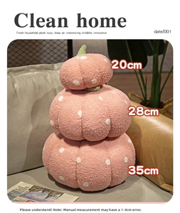 Detailed view of pink polka dot pumpkin plush pillows in three stacked sizes on a sofa