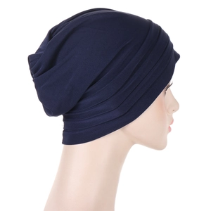 Detailed side view of navy blue pleated turban hat with soft elastic fabric texture