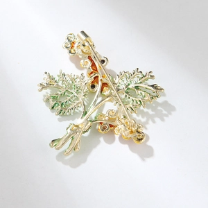 Elegant pine cone brooch with green leaves and gold finish, rear view with pin clasp