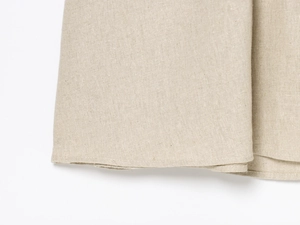 Detail von Leinenstoff mit hochwertiger Saumnaht an einem beigen Maxikleid