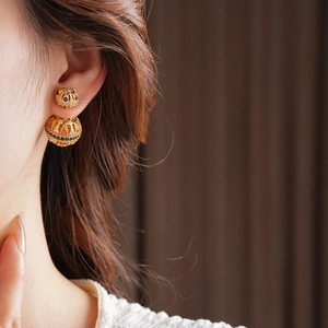 Gros plan de boucles d'oreilles vintage doubles billes plaquées or 18k avec pierres colorées
