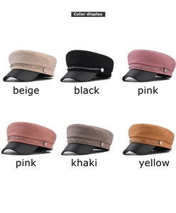 Détail de plusieurs casquettes gavroche avec chaîne en métal et visière en cuir