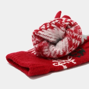 Close-up of thick knitted winter gloves with red and white snowflake Christmas patterns