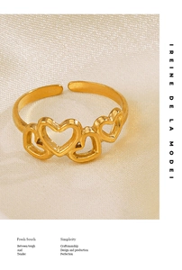 Détail d'une bague dorée 18K avec trois cœurs ajourés sur fond de soie délicate