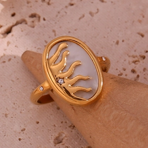 Detailed macro of 18K gold ring with sunburst sun motif on white mother of pearl inlay