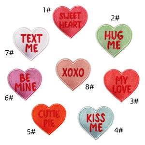 Close-up of colorful heart-shaped embroidered denim patches with iron-on love quotes