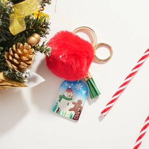 Christmas snowman keychain with red plush ball, green tassel, and acrylic charm decoration