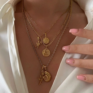 Ensemble de colliers superposés plaqués or 18k avec pendentifs soleil et ange sur modèle