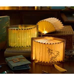 Macro view of folding book lamps featuring calligraphy and ink bamboo art on paper pages