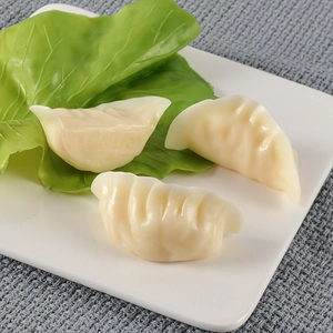 Realistic PVC dumpling models on a white plate with lettuce for display and photography