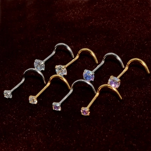 Macro view of gold and silver nose studs with round cubic zirconia on velvet