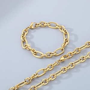 Macro shot of gold-plated stainless steel Figaro chain necklace and bracelet set