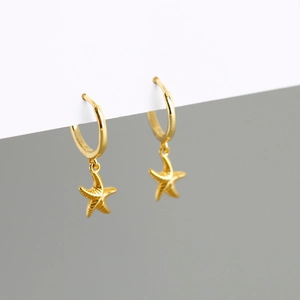 Detailed view of gold plated S925 sterling silver huggie hoops with starfish charms