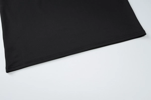 Close-up of the double-stitched hem and high-density knit fabric on a black dress