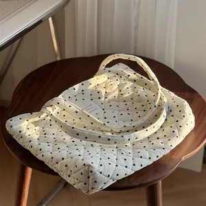 Sac cabas matelassé en velours côtelé à motifs cœurs sur tabouret vintage