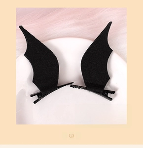 Detail view of black bat wing hair clips with soft felt texture and metal alligator base